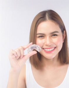 The female patient of Banyule Dental is holding her clear aligner